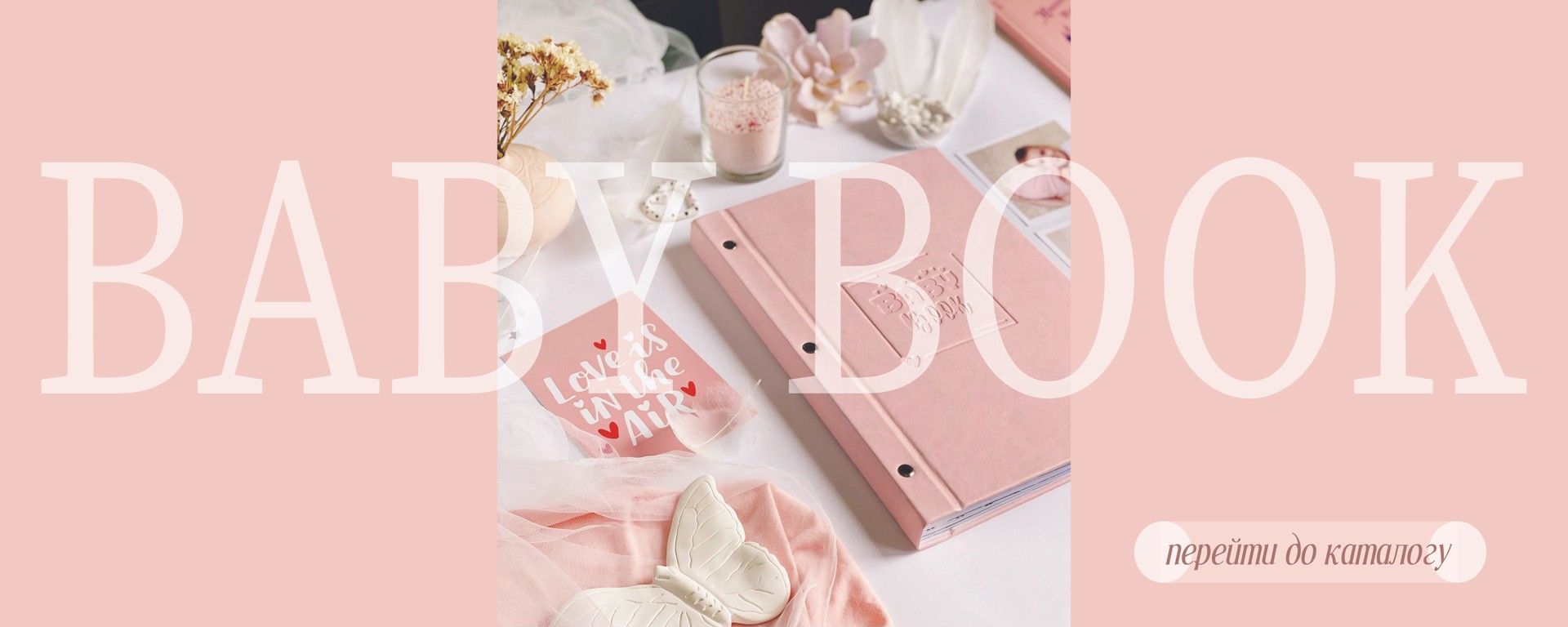 Рожевий baby book на столі з декором навколо. Текст на зображені "baby book "